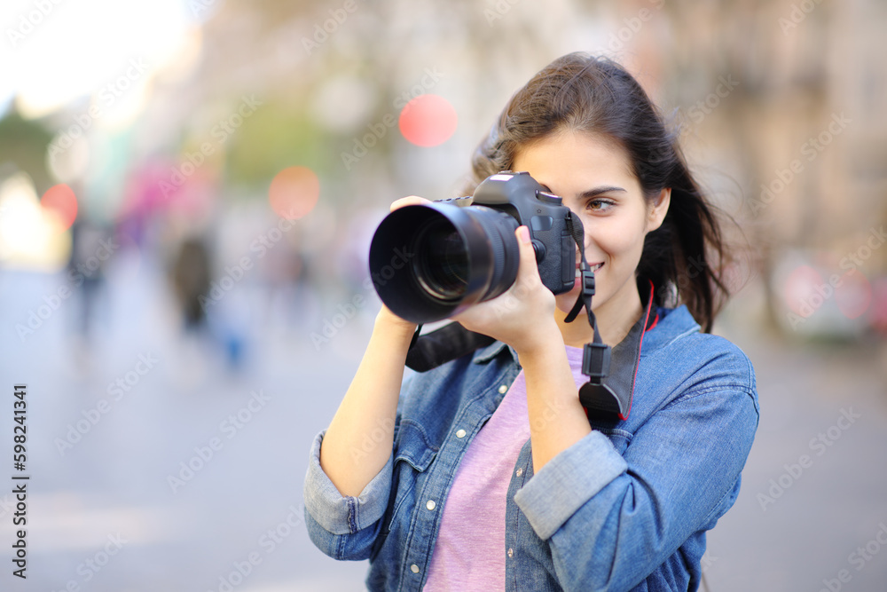 Happy photographer taking photos standing in the street