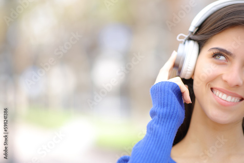 Happy woman with headphone looks at side