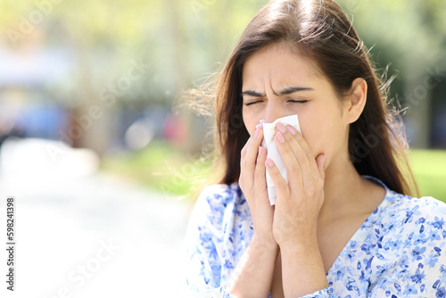 Ill woman blowing or coughing on tissue