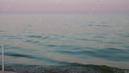 Sea in rays of setting sun. Calm sea. Sunset on the seashore. 4K Resolution 
