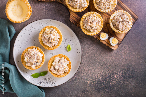 Obraz na płótnie Appetizing tartlets with egg, canned tuna and onion salad on a plate on the table top view w salonie