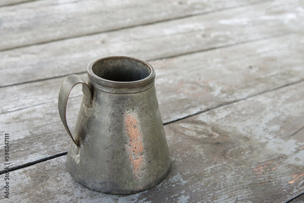 Old antique vase, copper jug, pot with handle on an old wooden table. Minimal concept of an empty object, mockup. Old antique vase, copper jug, pot with handle on an old wooden table. Minimal concept of an empty object, mockup.