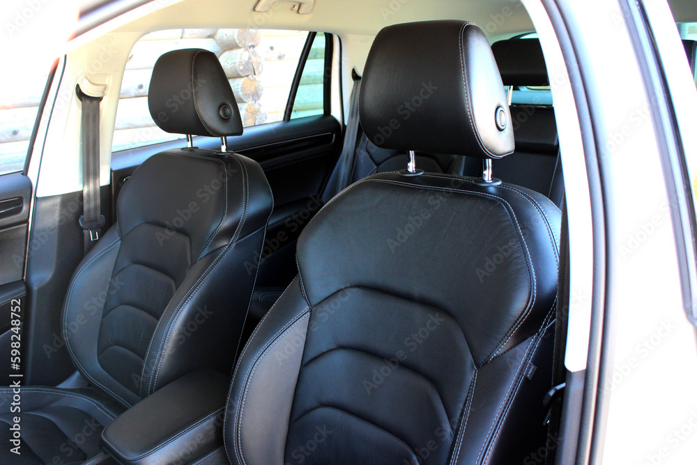 Close-up of the driver and passenger seats. Clean after washing the rear passenger seats of matte black genuine leather inside the interior of an expensive luxury suv.