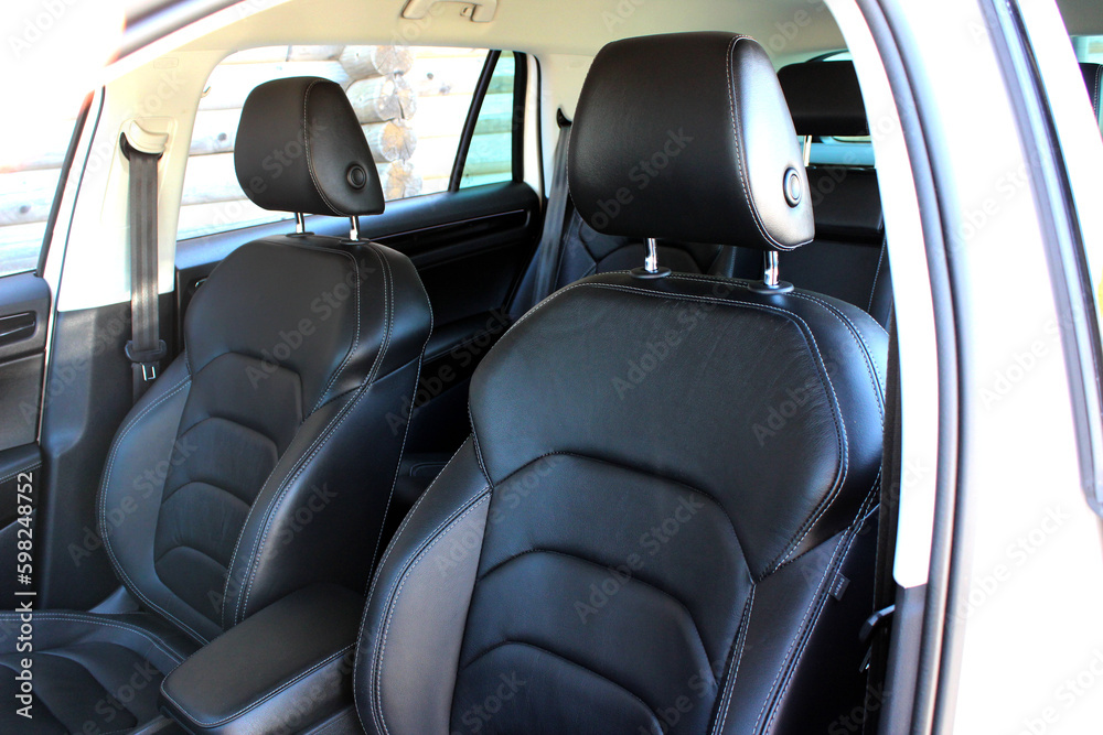 Close-up of the driver and passenger seats. Clean after washing the rear passenger seats of matte black genuine leather inside the interior of an expensive luxury suv. Close-up of the driver and passenger seats. Clean after washing the rear passenger seats of matte black genuine leather inside the interior of an expensive luxury suv.