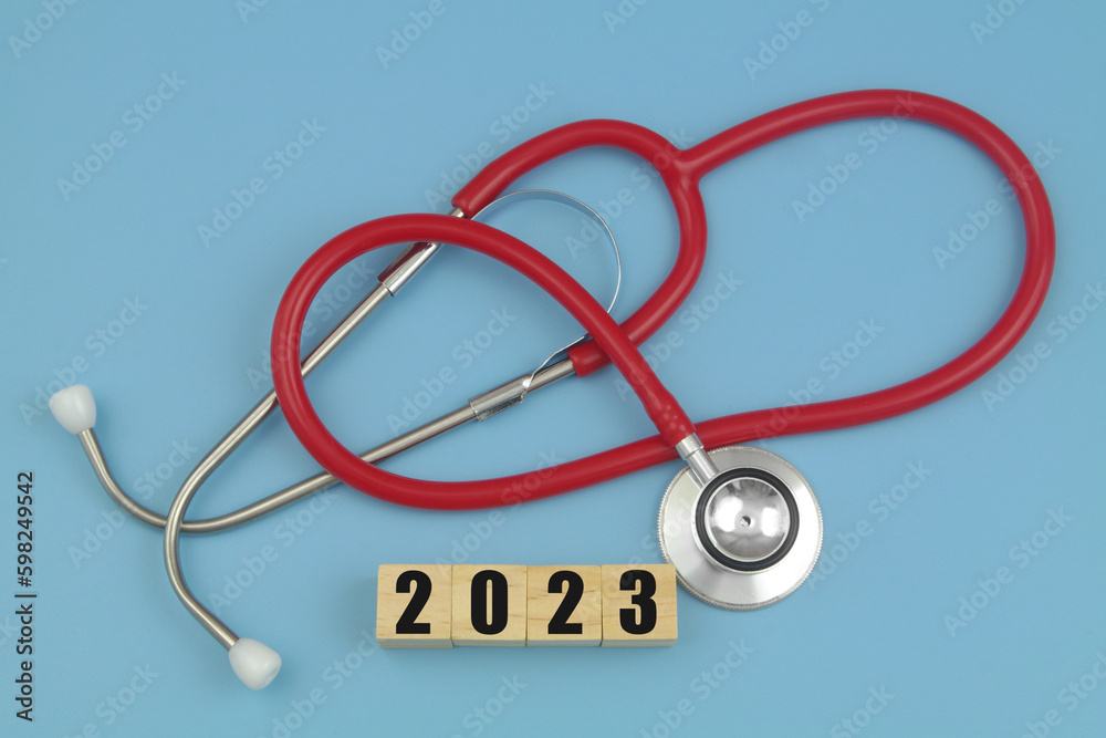 Red stethoscope with numbers 2023 on wooden cubes. Medical events and meetings in 2023 concept. Red stethoscope with numbers 2023 on wooden cubes. Medical events and meetings in 2023 concept.