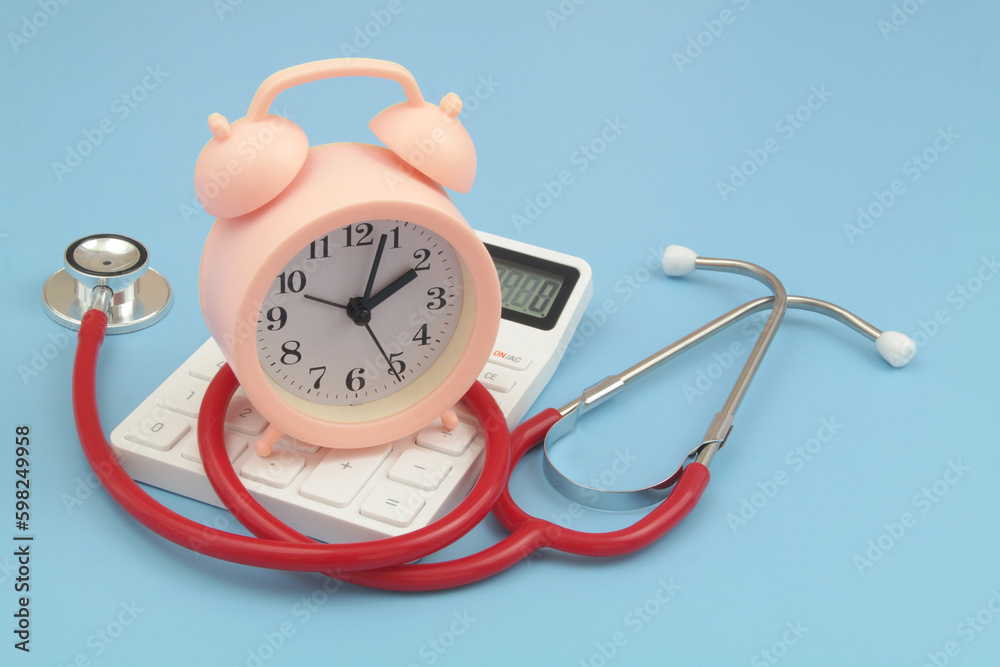 Red stethoscope and clock on calculator. Red stethoscope and clock on calculator.