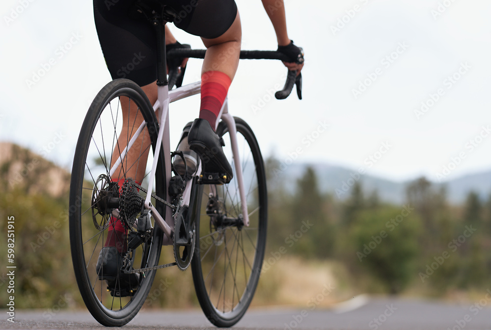 Fototapeta premium Male cyclist riding racing bicycle, man cycling on countryside summer road. Training for triathlon or cycling competition