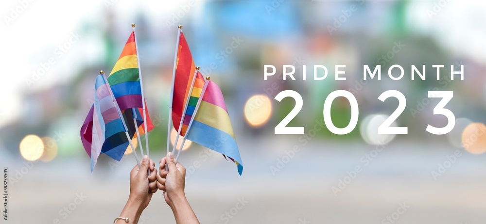 'Pride Month 2023' on rainbow flags and street bokeh background, concept for lgbtq+ people celebrations in pride month, June, around the world and calling out people to respect gender diversity. - obrazy, fototapety, plakaty 