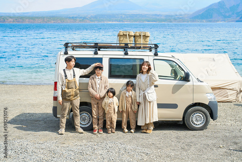 アウトドアを楽しむ家族とキャンピングカー