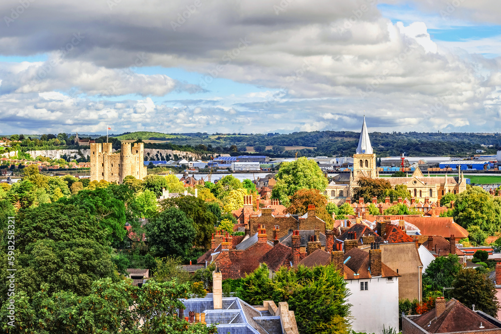 Aerial view of city of Rochester in Kent, England with medieval structures and cloudy sky.
