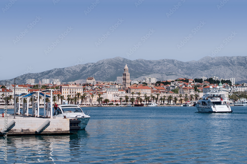 Travel by Croatia. Beautiful landscape with Split Old Town on sea promenade. Yacht in the harbour.
