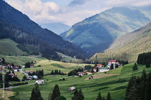 Alpine mountains landscape. Village on green valley land.