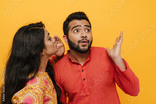 Valokuva Indian couple gossiping isolated over yellow background
