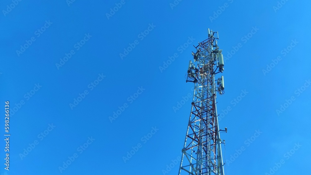 Technology background of silhouette from transmitter tower in blue clear sky during daylight