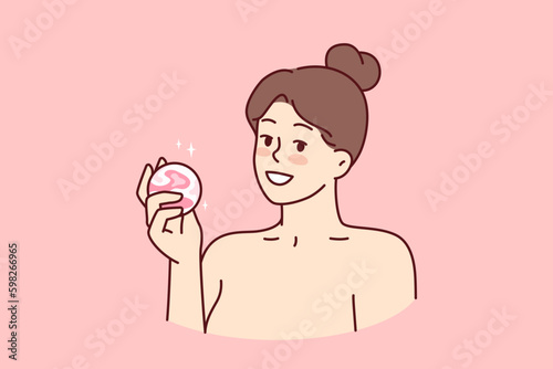 Woman with bath bomb in hands smiles as she prepares to take bath with aromatic substances. Happy girl with bare shoulders demonstrates bomb for comfortable water treatments or SPA Generative AI