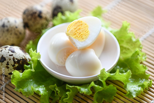 boiled eggs food, quail eggs on white bowl, breakfast eggs with fresh quail eggs and vegetable lettuce on table background