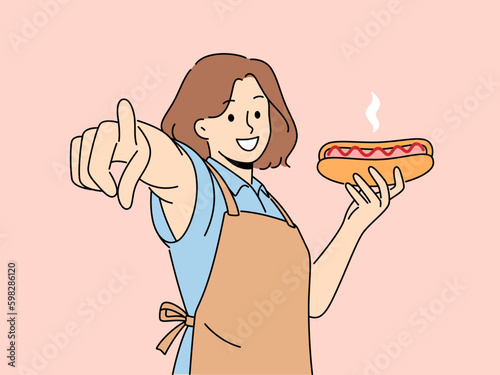 Smiling woman in apron holding hot dog point at screen. Happy waitress with fastfood in hands show at camera with finger. Vector illustration.  Generative AI