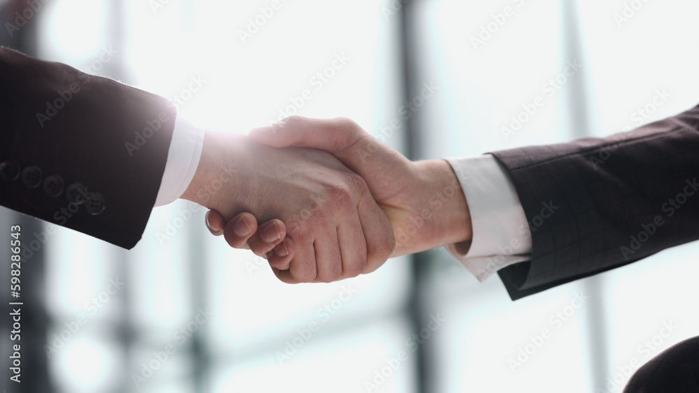 Close up businessman shaking hands with caucasian client.