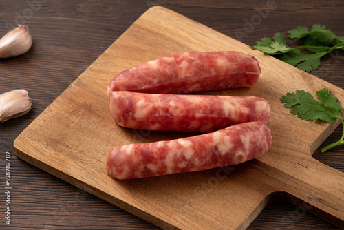 Raw Taiwanese sausage in garlic flavor in a plate on wooden table background.