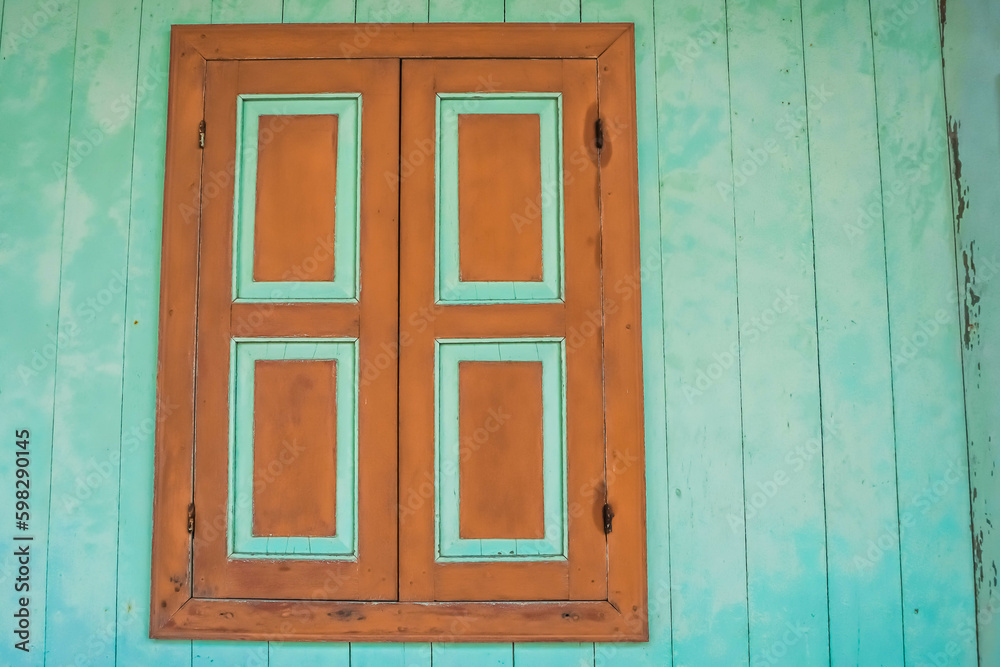 Closed Old wooden window with shutters on an wooden wall. Window on indonesian malay traditional house. Sumatran traditional house. Empty Blank Text Space.