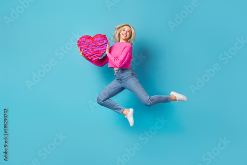 Full body photo of young overjoyed girl hold her valentine day present love giftbox from her boyfriend isolated on blue color background Generative AI