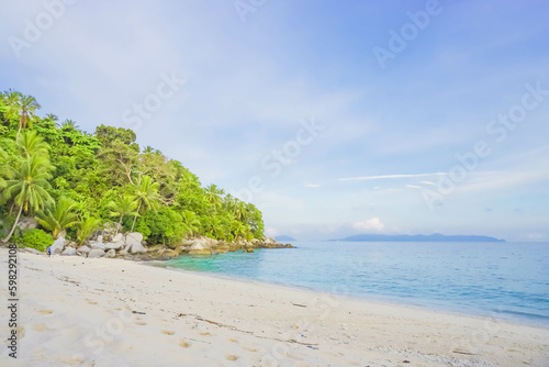 Durai Island, Anambas, Tropical beach with rocks, coconut trees, and blue sky with clouds on Sunny day. Summer tropical landscape, panoramic view. travel tourism panorama background concept.