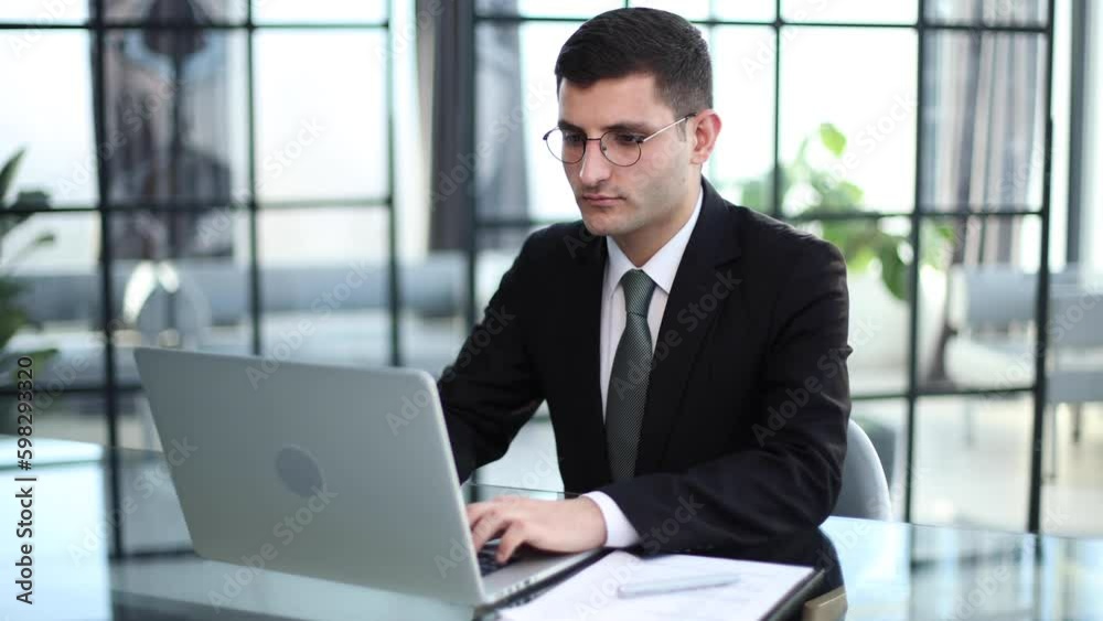 Business portrait - businessman sitting in in office working with laptop computer Business portrait - businessman sitting in in office working with laptop computer