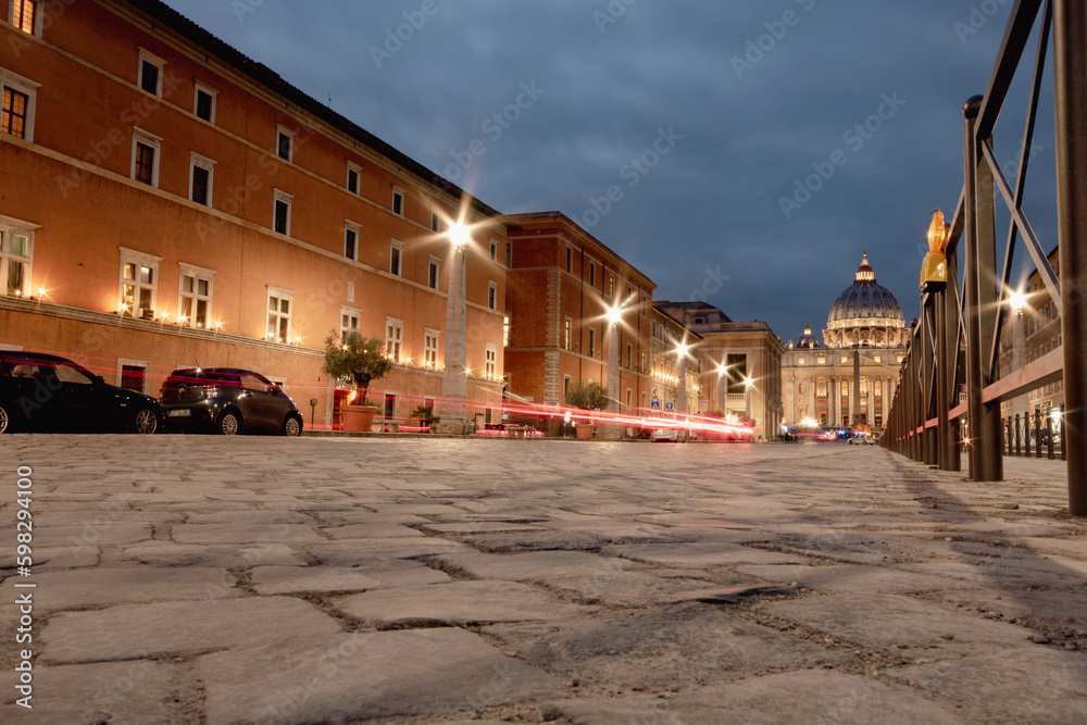 Rome at night, old stone road leading to St Peter's Square with traffic trails (long exposure)