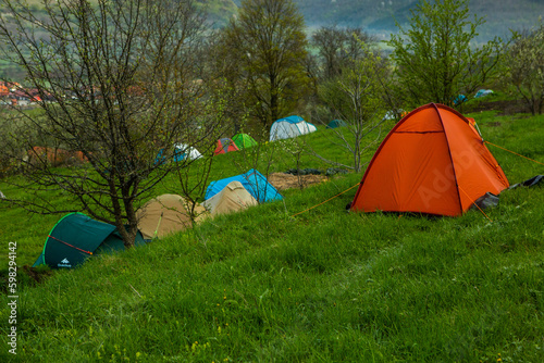 Camping tents on a green meadow in the mountains in spring. Rest with the tent in nature © romeof