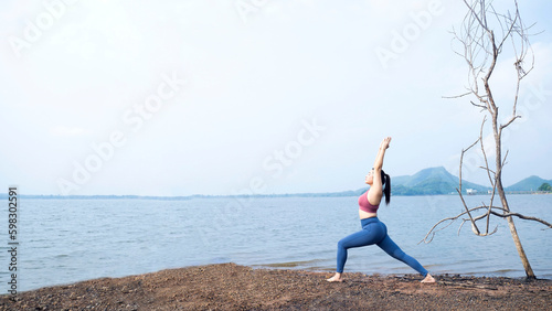 The asian woman do yoga at home in holiday time, on modern concept and healthy. Nature  background with exercise  in the forest with lake, female happiness concept © EEarth