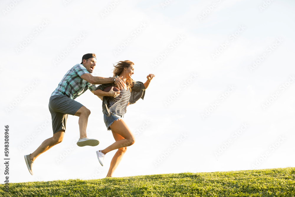 Woman and man running on hill in park Woman and man running on hill in park