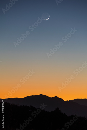 United States, New Mexico, Santa Fe, Crescent moon over Jemez Mountains photo