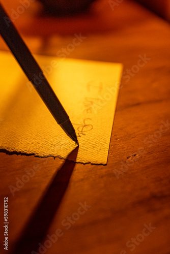 Close-up of pen writing on linen notecard