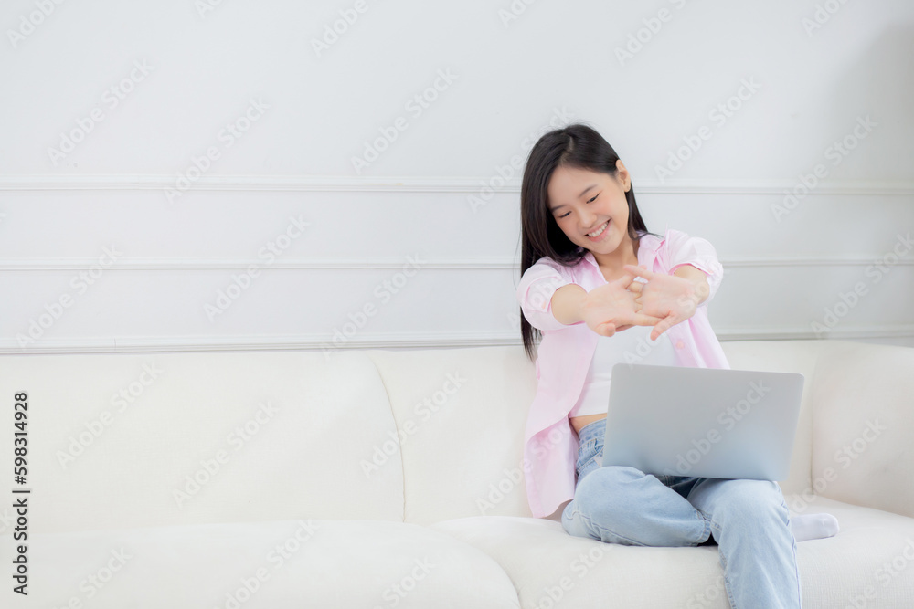 Beautiful young asian businesswoman sitting on sofa and working from home and break while stretch arm for relax in living room at home, woman is freelance working on laptop computer, business concept. Beautiful young asian businesswoman sitting on sofa and working from home and break while stretch arm for relax in living room at home, woman is freelance working on laptop computer, business concept.