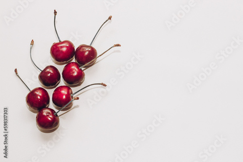 Ripe red cherries in on white table.