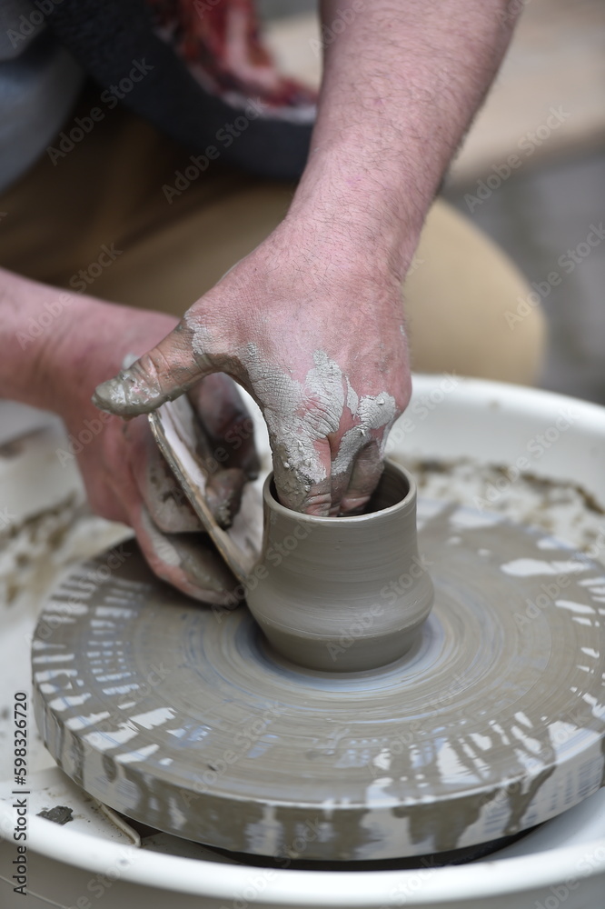 Detail shot with hands of a potter making handmade pottery