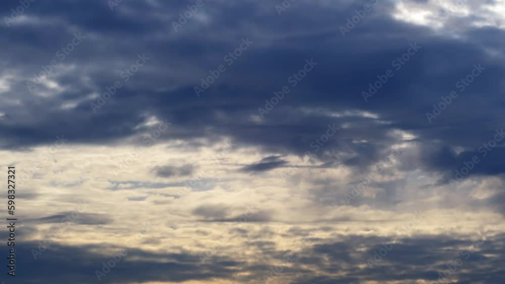 Dark background with clouds floating across the sky in several dense layers. Morning sky with clouds and sun rays. Dark background with clouds floating across the sky in several dense layers. Morning sky with clouds and sun rays.