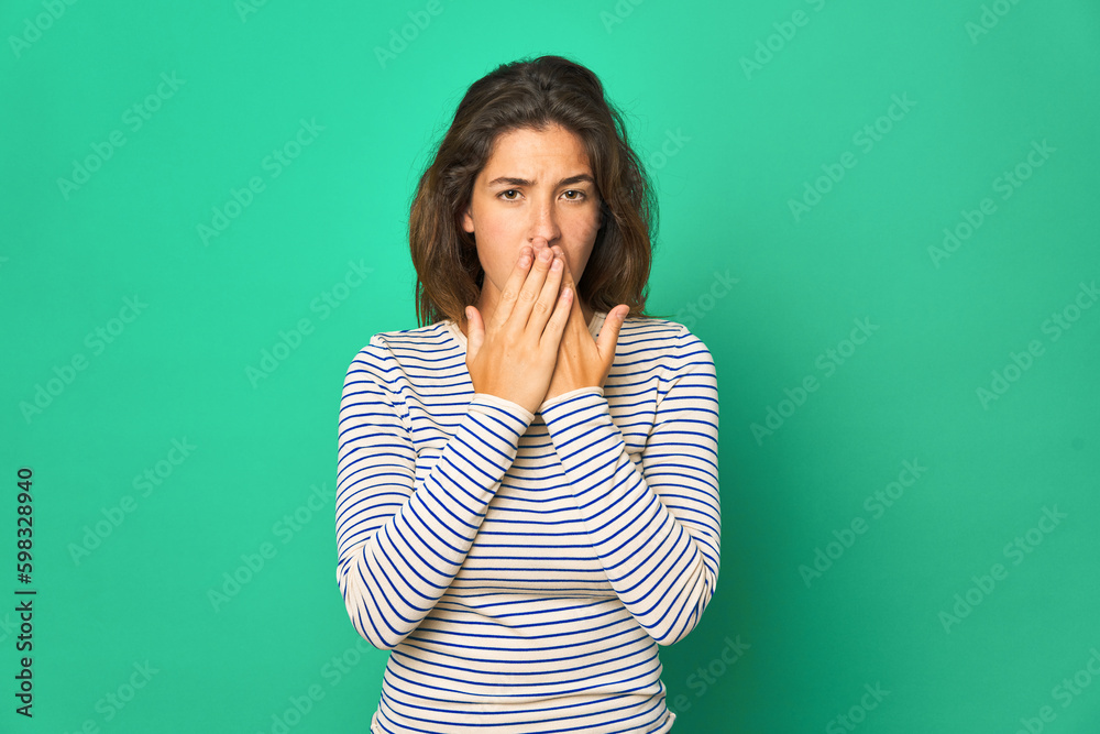 Young caucasian woman isolated shocked, covering mouth with hands, anxious to discover something new. Young caucasian woman isolated shocked, covering mouth with hands, anxious to discover something new.