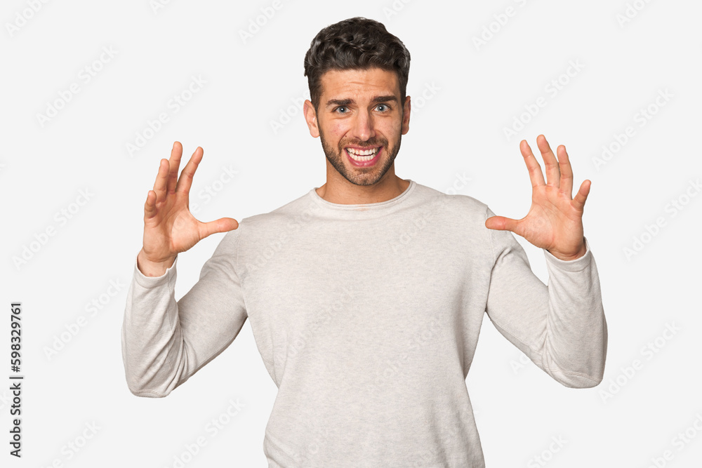 Young handsome man isolated screaming to the sky, looking up, frustrated.