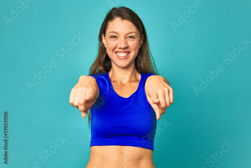 A young caucasian woman isolated cheerful smiles pointing to front.