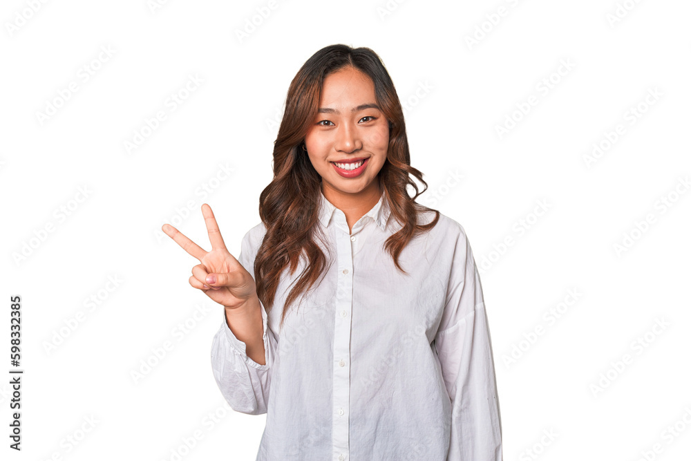 A young chinese woman showing victory sign and smiling broadly. A young chinese woman showing victory sign and smiling broadly.