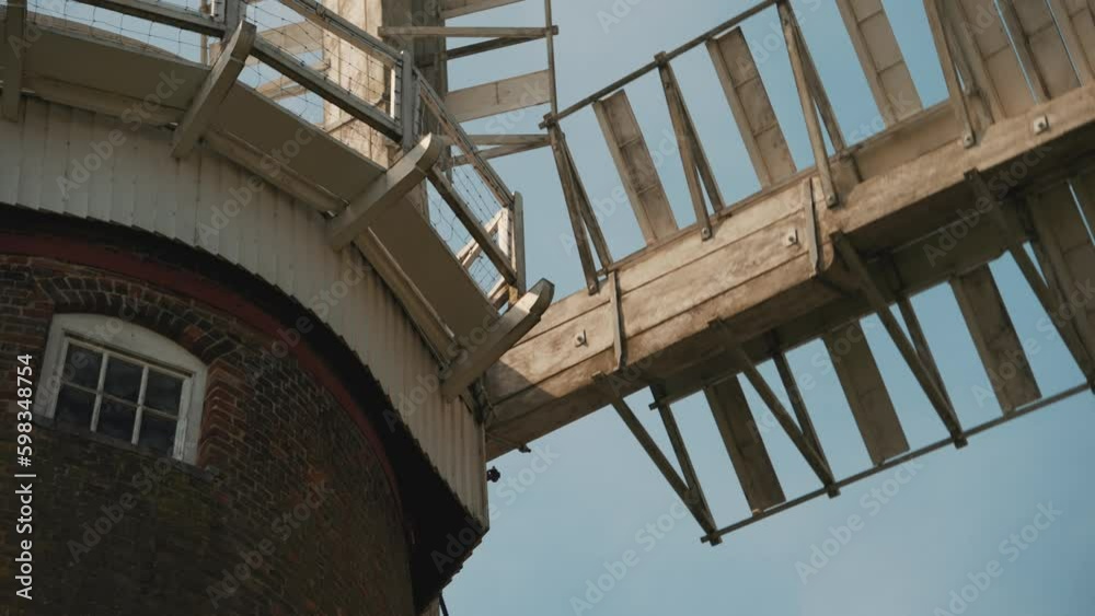 Windmill blades spinning beneath a blue sky. Norfolk Broads, water pump, pumping station, mill, wind power, eco friendly, traditional technology, farming rural machine Windmill blades spinning beneath a blue sky. Norfolk Broads, water pump, pumping station, mill, wind power, eco friendly, traditional technology, farming rural machine