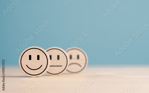 Wooden label with happy normal and sad face icons for experience survey services and products review concept. Customer or Client show Good Neutral or Negative feedback and satisfaction rating. photo