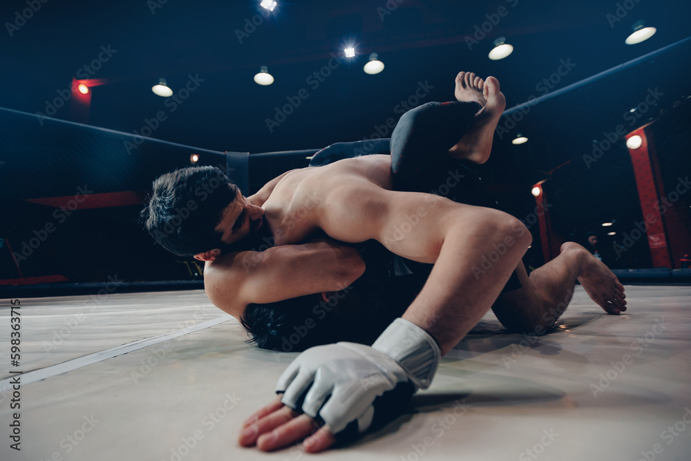 Boxers Aggressive fighter in MMA tournament in ring cargo octagon, dark ...