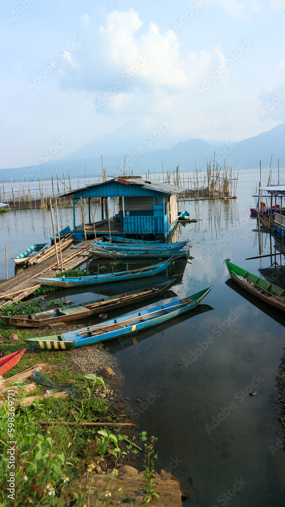 Fototapeta Fishing boats on the edge of Rawa Pening lake at sunrise, sunset. Rawa Pening is a lake located in three districts namely Tuntang, Ambarawa, Banyubiru Semarang.