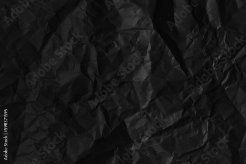 Black crumpled paper texture in low light background