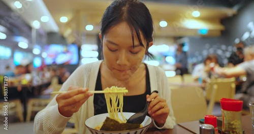 Beautiful asian woman enjoy to eat noodle in restaurant. Lefestyle, Travel, Culture and Happiness concept.