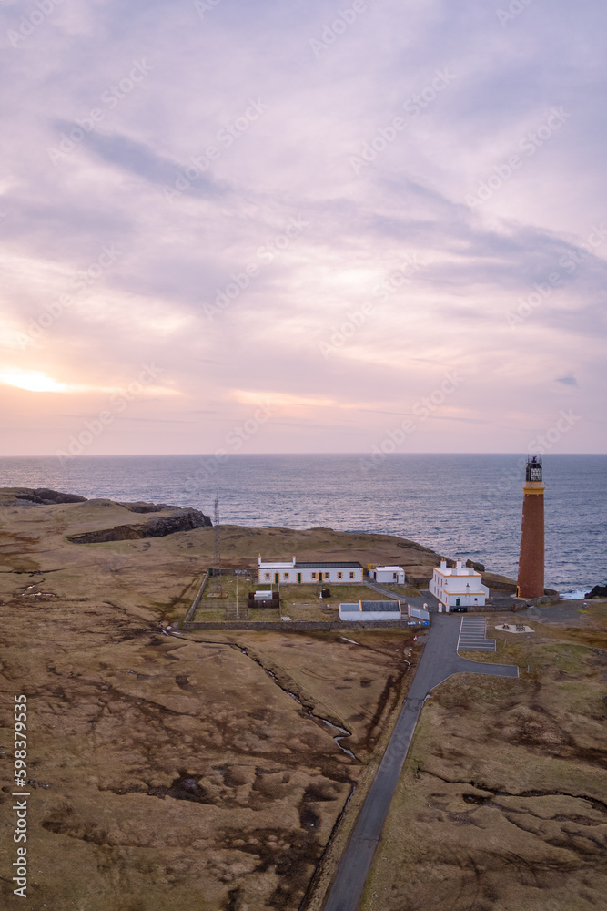 Aerial view of sunset and lilac sky over Butt of Lewis Lighthouse, Scotland 