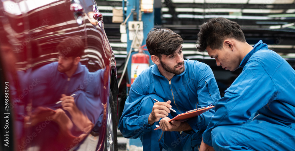 automotive mechanic men checking at car tyre rubber condition needed for replacement, man pointing hand at wheel following maintenance checklist document, after service at auto repair shop concept