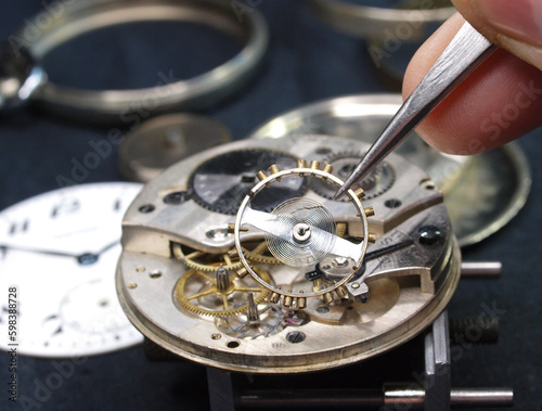 watchmaker reparaing vintage watch mechanism close up detail